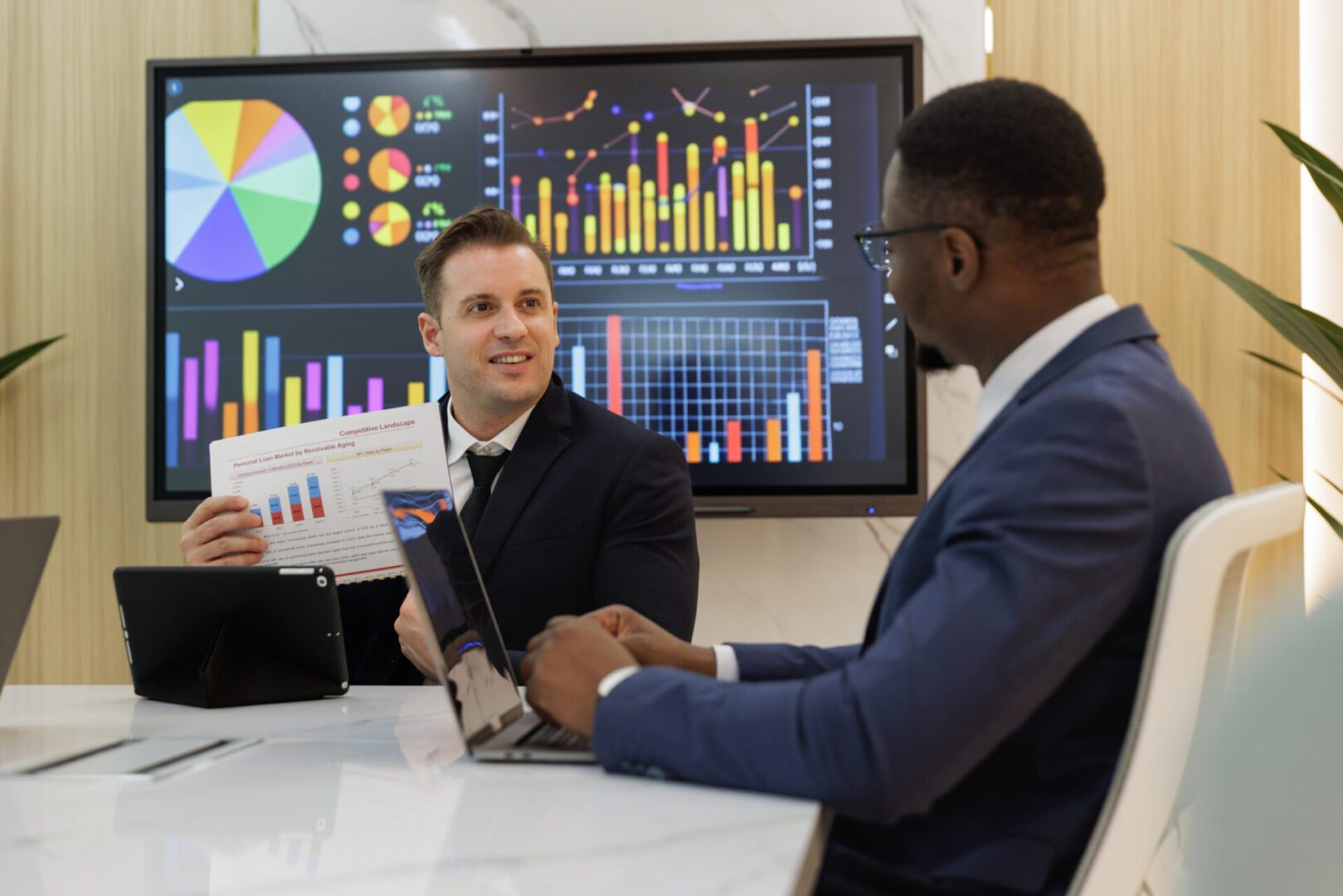 Professionals analyzing graphs on screen